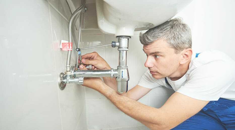 The plumber man repair the leaky faucet tap